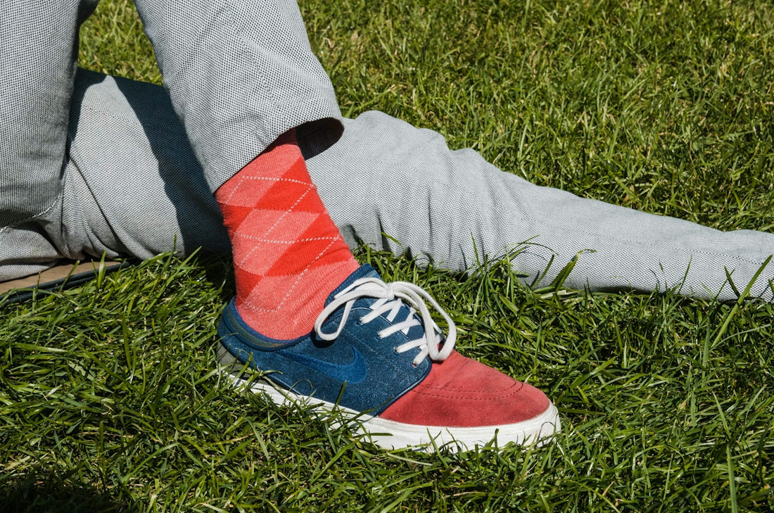 person wearing white blue and red socks and white nike sneakers