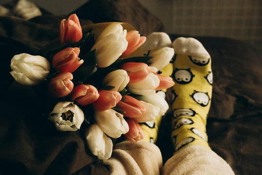 a bouquet of tulips and tulip socks on a bed