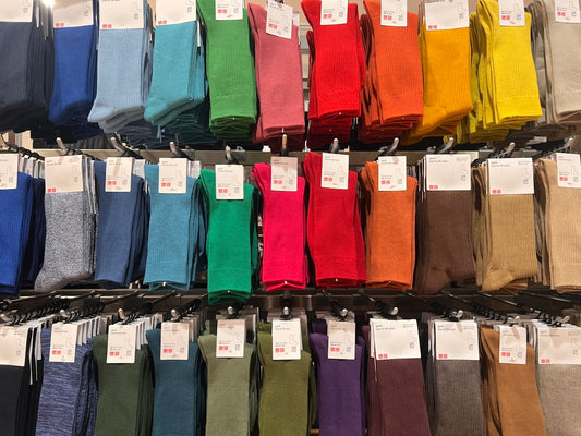 A display case filled with lots of different colored socks