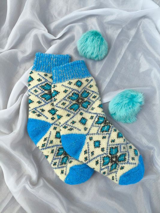 A pair of blue and white socks with pom poms