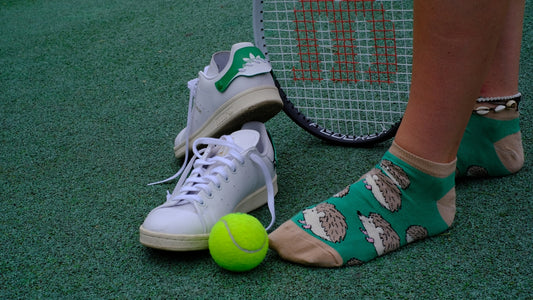 A tennis player's feet with a tennis racket and a tennis ball