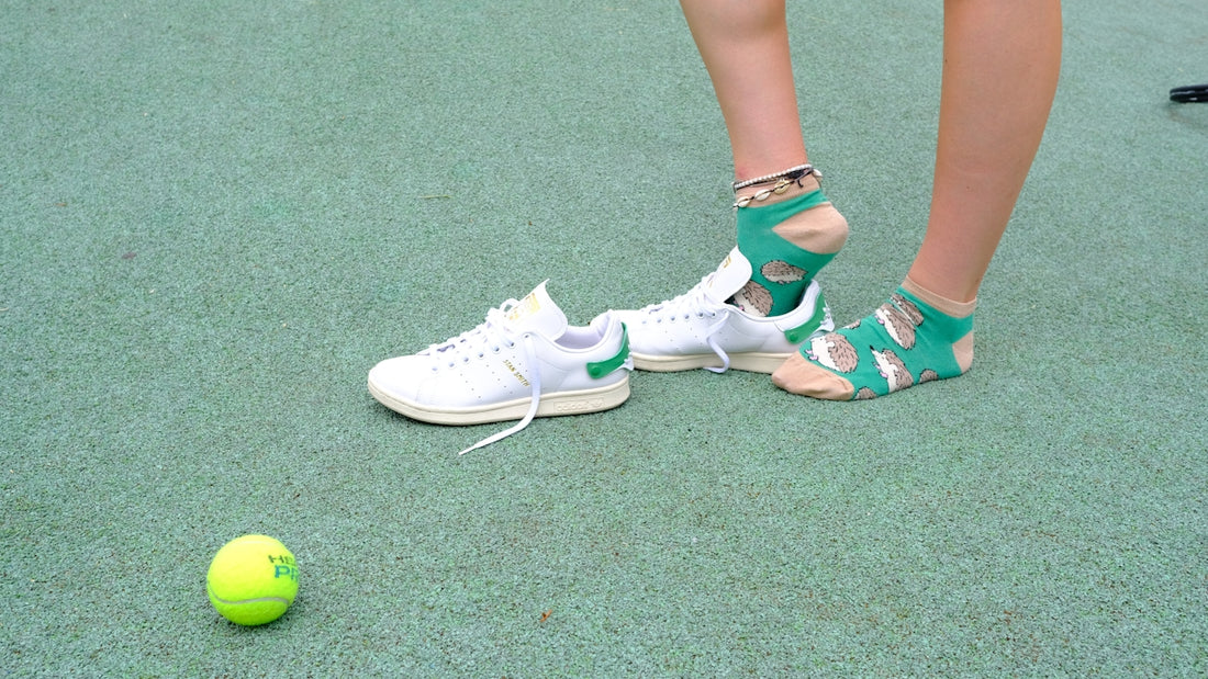 A person standing next to a tennis ball on a court
