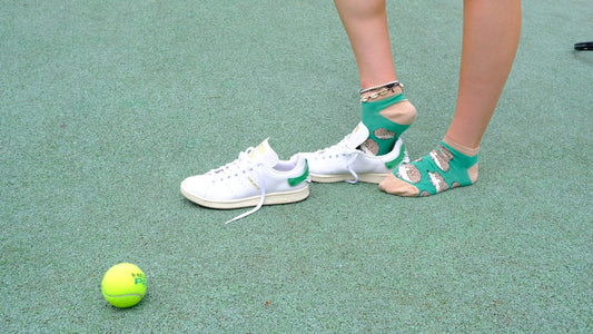 A person standing next to a tennis ball on a court