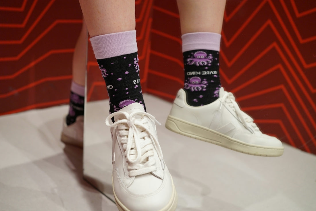 A person wearing white shoes with black socks
