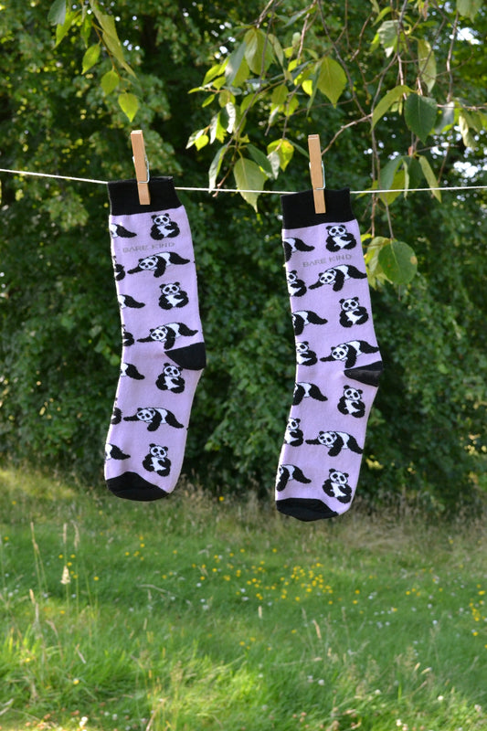 A pair of panda socks hanging from a clothes line