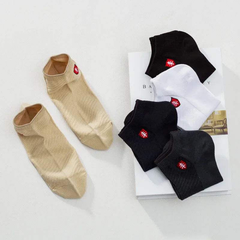 Set of ankle socks in beige, black, and white with logo, made from soft, breathable material.