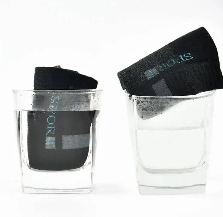 Black sports socks submerged in water, showcasing moisture-wicking and quick-dry features.