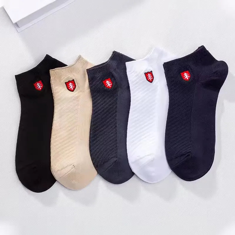 Set of five colorful ankle socks in black, beige, gray, white, and dark blue with a stylish logo.